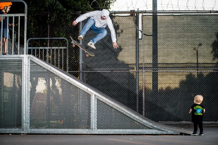 Kickflip for the kids. Huf kickflips on a bank with a small kid in the frame Photo Reda